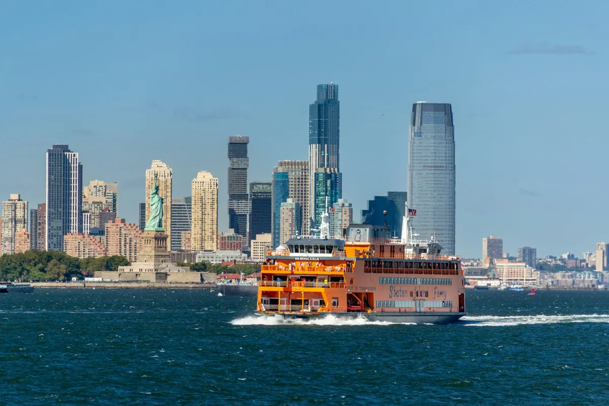 The Staten Island Ferry crossing New York Harbor with the Jersey City skyline behind